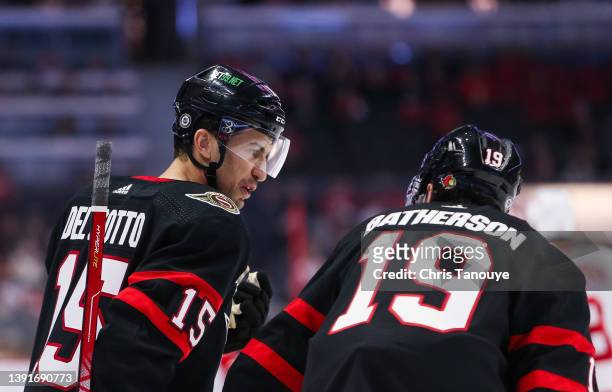 Michael Del Zotto of the Ottawa Senators talks with his teammate Drake Batherson during a stoppage in play against the Detroit Red Wings at Canadian...
