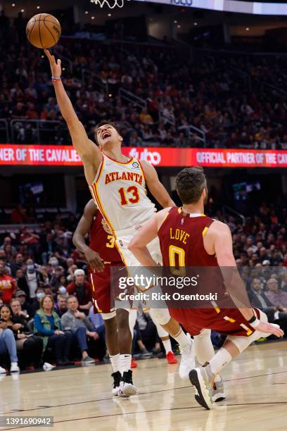 Bogdan Bogdanovic of the Atlanta Hawks shoots and is fouled by Kevin Love of the Cleveland Cavaliers in the first half at Rocket Mortgage Fieldhouse...