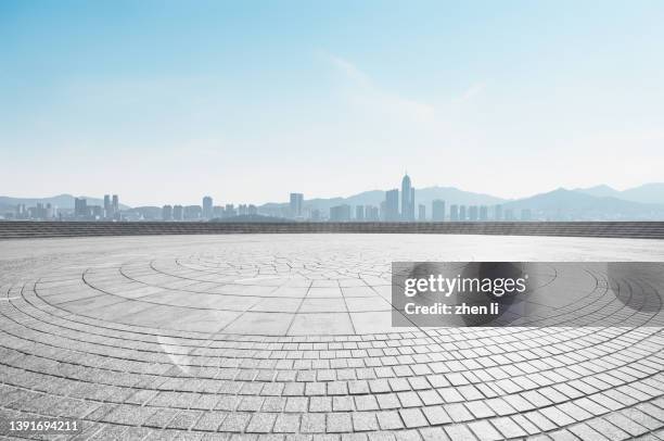empty town square against urban skyline - städtischer platz stock-fotos und bilder