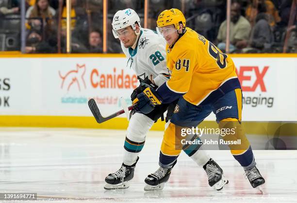 Tanner Jeannot of the Nashville Predators skates against Timo Meier of the San Jose Sharks during an NHL game at Bridgestone Arena on April 12, 2022...