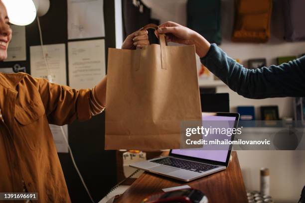 service à la clientèle par un vendeur - sachet en papier photos et images de collection