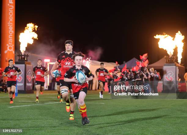 Crusaders captain Scott Barrett with a young fan who got to bring the ball out during the round four Super Rugby Pacific match between the Crusaders...