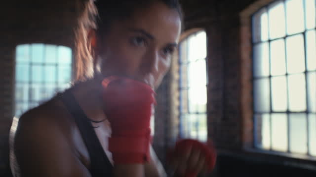 4k video footage of a beautiful young boxer training at the gym
