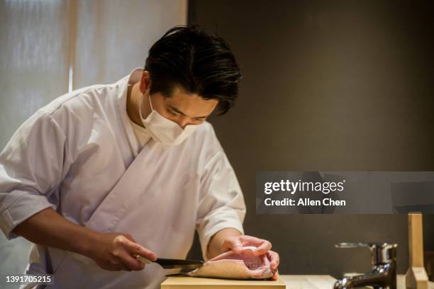 the chef of japanese food makes sushi at the sushi bar - 郷土料理　日本 ストックフォトと画像