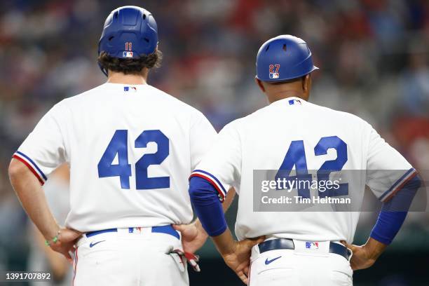 Charlie Culberson of the Texas Rangers and Tony Beasley stand near third base in the game against the Los Angeles Angels at Globe Life Field on April...