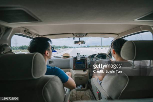 pareja gay asiática china que viaja utilizando el mapa de carreteras de la aplicación móvil con autocaravana para un viaje por carretera de vacaciones durante el fin de semana - perspectiva de un coche fotografías e imágenes de stock