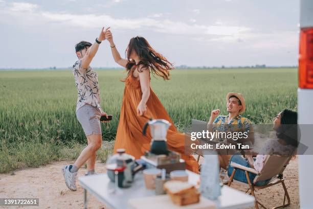 asian chinese gay couple enjoying weekend leisure time with friends at rice paddy field travel with campervan dancing - couple dance stock pictures, royalty-free photos & images