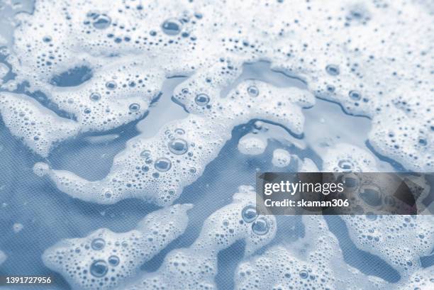 top view movement of bath foam inside bathtub copy space - waschpulver stock-fotos und bilder