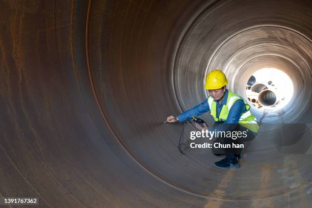 a female engineer used a hardness tester to test steel inside the steel pipe - asian violence stock pictures, royalty-free photos & images