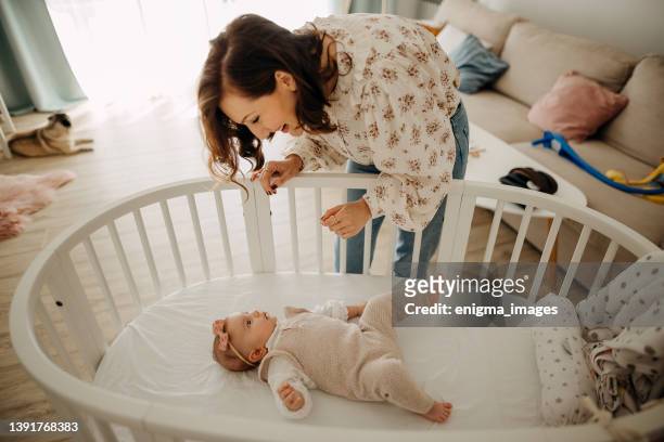 newborn girl lies in white cradle - wieg stockfoto's en -beelden