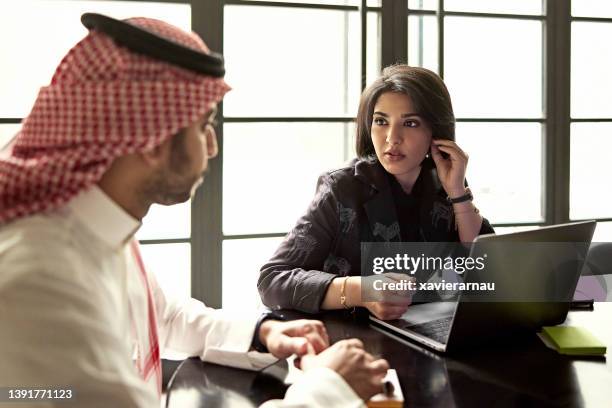 middle eastern corporate colleagues conversing at meeting - saudi women stock pictures, royalty-free photos & images