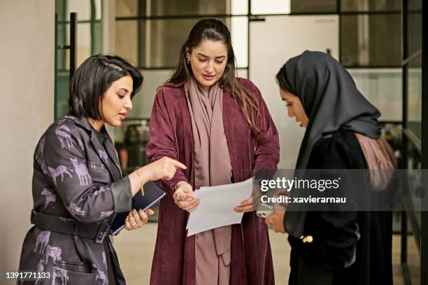 middle eastern businesswomen discussing documents - middle east clothing stock pictures, royalty-free photos & images
