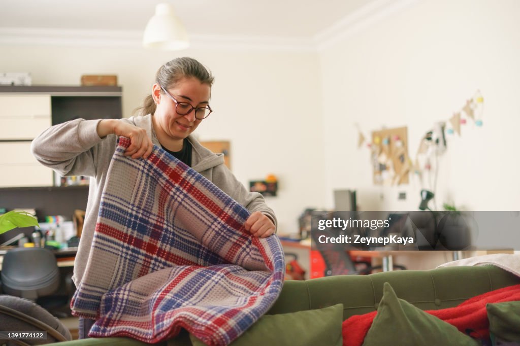 Woman folding a blanket.