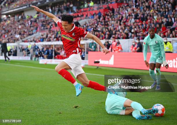 Jeong Woo-Yeong of SC Freiburg is tackled by Cristian Gamboa of VfL Bochum during the Bundesliga match between Sport-Club Freiburg and VfL Bochum at...