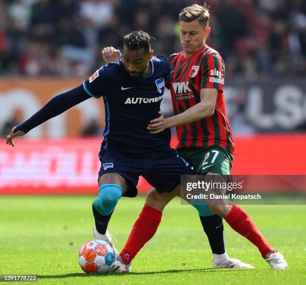 Kevin-Prince Boateng of Hertha BSC is challenged by Alfreo Finnbogason of Augsburg during the Bundesliga match between FC Augsburg and Hertha BSC at...