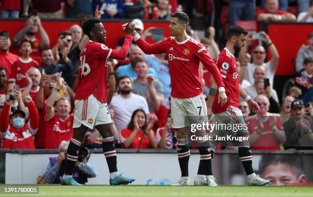 Cristiano Ronaldo of Manchester United celebrates with team mate Anthony Elanga after scoring their sides first goal during the Premier League match...