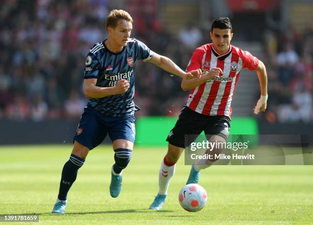 Martin Odegaard of Arsenal is marked by Mohamed Elyounoussi of Southampton during the Premier League match between Southampton and Arsenal at St...