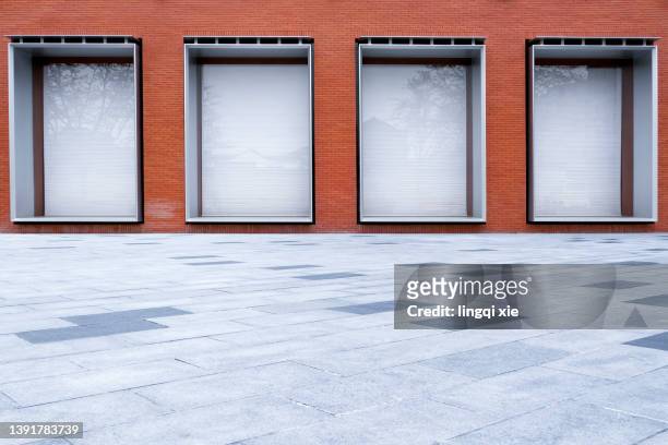 white shop window on red brick wall - empty store window stockfoto's en -beelden