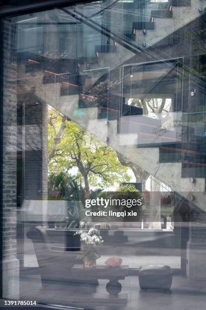 the window glass reflects the abstract pattern formed by the streetscape - empty store window stock-fotos und bilder