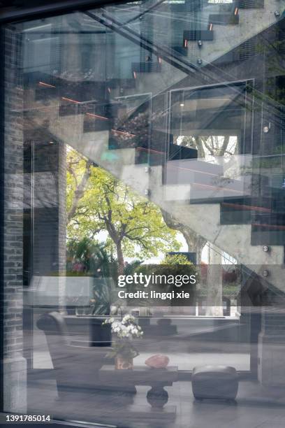 the window glass reflects the abstract pattern formed by the streetscape - etalage stockfoto's en -beelden
