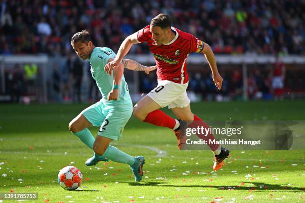 Cristian Gamboa of VfL Bochum battles for possession with Christian Guenter of SC Freiburg during the Bundesliga match between Sport-Club Freiburg...