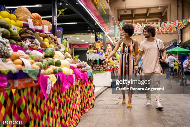 porträt von schönen touristen, die auf dem städtischen markt spazieren gehen - markthalle stock-fotos und bilder