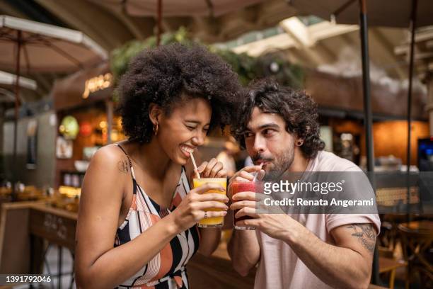 portrait of beautiful tourists couple drinking juice in the municipal market - municipal market of sao paulo stockfoto's en -beelden