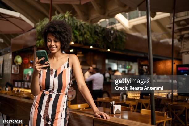 portrait of beautiful woman using smart phone in the municipal market - municipal market of sao paulo stockfoto's en -beelden