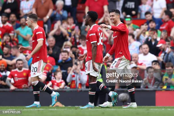 Cristiano Ronaldo of Manchester United celebrates with team mate Anthony Elanga after scoring their sides third goal and hat-trick during the Premier...