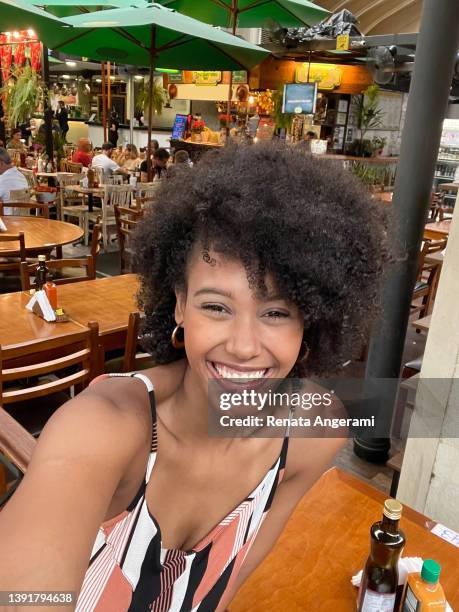 porträt einer schönen frau, die ein selfie auf dem städtischen markt macht - african woman shopping stock-fotos und bilder