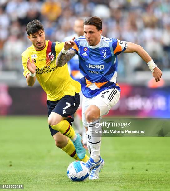 Riccardo Orsolini of Bologna marks Luca Pellegrini of Juventus during the Serie A match between Juventus and Bologna FC at Allianz Stadium on April...