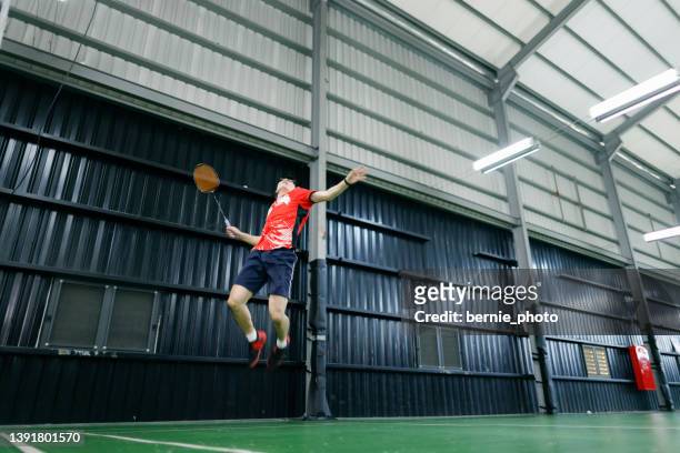 il momento di saltare e distruggere il gioco del badminton - playing badminton foto e immagini stock