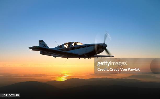 private plane and dramatic sunset over misty islands - propellervliegtuig stockfoto's en -beelden