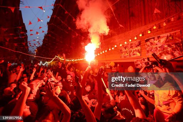 People celebrate after breakfast with fireworks during a mass Iftar gathering at Ezbet Hamada in Al Matariyyah district during the holy month of...