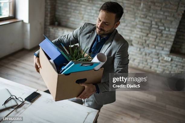 serious businessman leaving his office after quitting a job. - quitting job stock pictures, royalty-free photos & images
