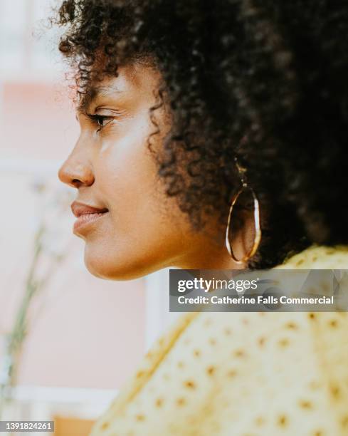 simple side profile of a beautiful young black woman with an afro hairstyle - afro man washing stock-fotos und bilder