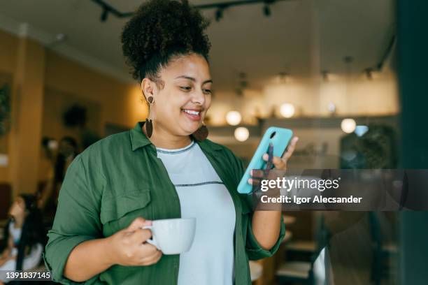 woman using smartphone at coffee shop - braziliaanse etniciteit stockfoto's en -beelden