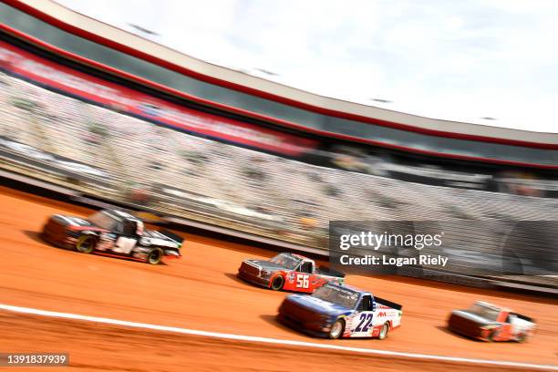 Austin Wayne Self, driver of the AM Technical Solutions Chevrolet, and Timmy Hill, driver of the Hill Motorsports Toyota, race during qualifying for...