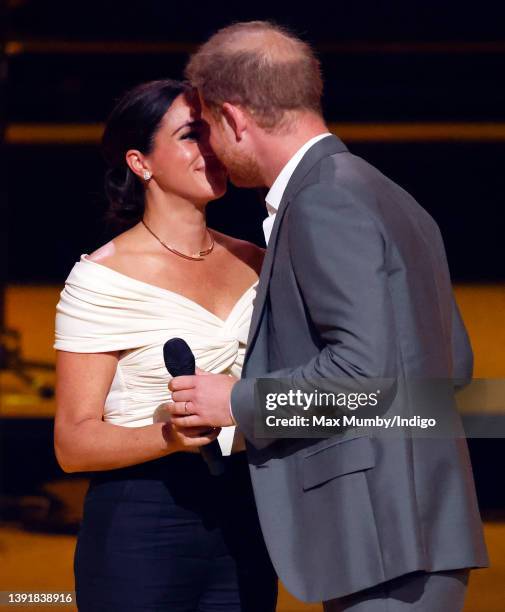 Meghan, Duchess of Sussex and Prince Harry, Duke of Sussex kiss whilst on stage during the Opening Ceremony of the Invictus Games 2020 at Zuiderpark...