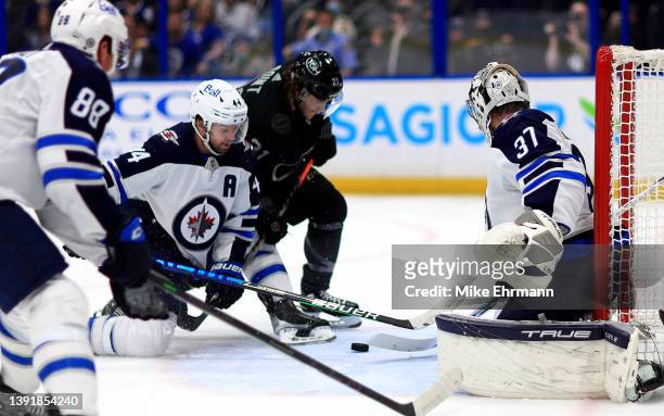 Connor Hellebuyck of the Winnipeg Jets stops a shot from Brayden Point of the Tampa Bay Lightning in the second period during a game at Amalie Arena...