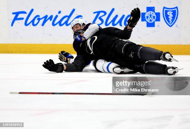 Corey Perry of the Tampa Bay Lightning and Josh Morrissey of the Winnipeg Jets fight for the puck in the third period during a game at Amalie Arena...