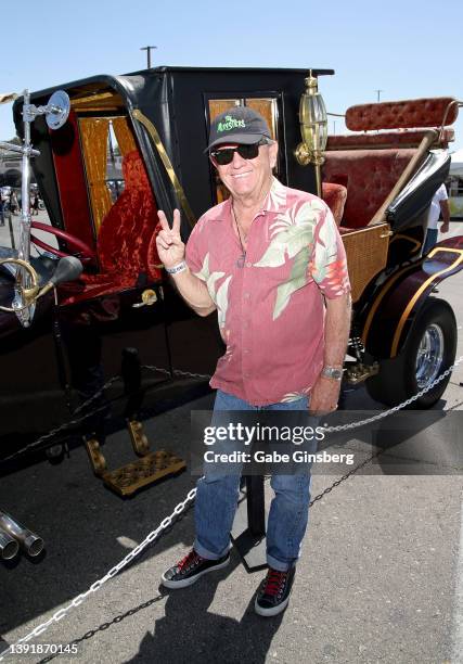 Actor Butch Patrick poses next to the The Munsters Mobile from the television show "The Munsters" during the car show at the 25th anniversary of the...