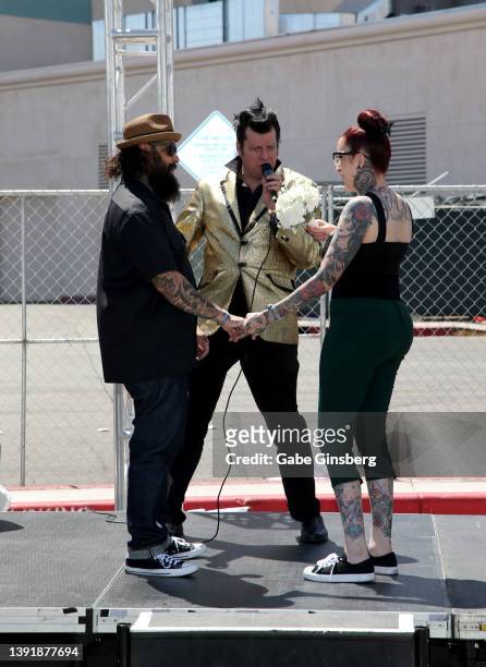 Elvis Presley impersonator Brian Mills officiates a wedding renewal ceremony between Jay Rivera and Ricky Rivera of Texas during the car show at the...