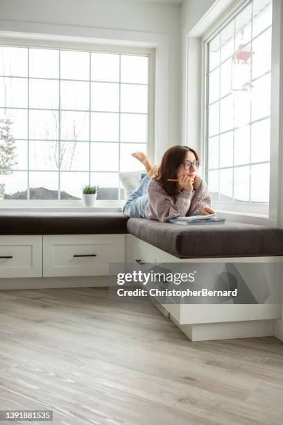 teenager girl student looking out window - reading nook stock pictures, royalty-free photos & images