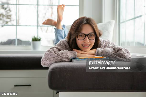 happy teenager girl student laying on books - nicho imagens e fotografias de stock