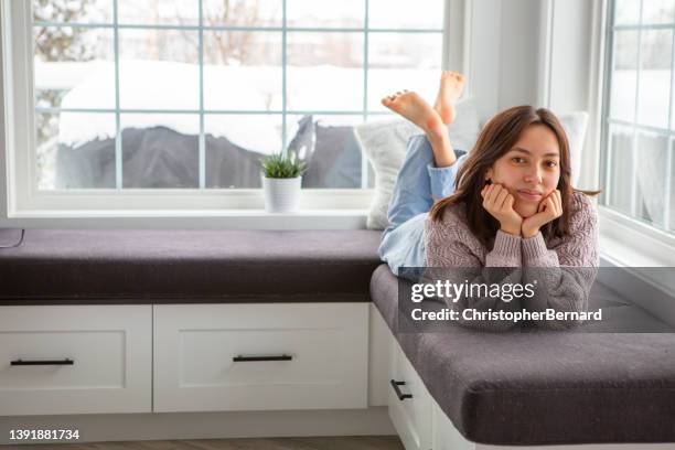 hermosa adolescente de raza mixta relajándose en casa - girls barefoot in jeans fotografías e imágenes de stock