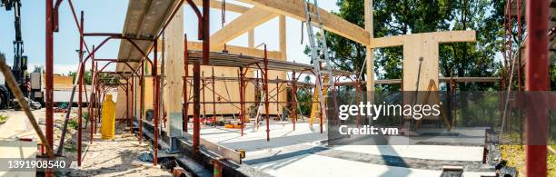 building wooden house in progress, beam frame and steel modular scaffolding - construction material stock pictures, royalty-free photos & images