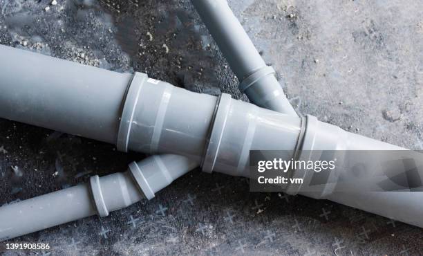 drain piping, grey plastic pipes various diameters connecting into one - pipe stockfoto's en -beelden