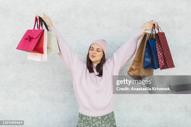 smiling woman with shopping bags over grey background. - coupons stock pictures, royalty-free photos & images