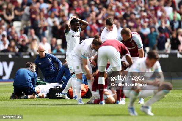 Maxwel Cornet of Burnley reacts after Ashley Westwood of Burnley receives medical attention during the Premier League match between West Ham United...
